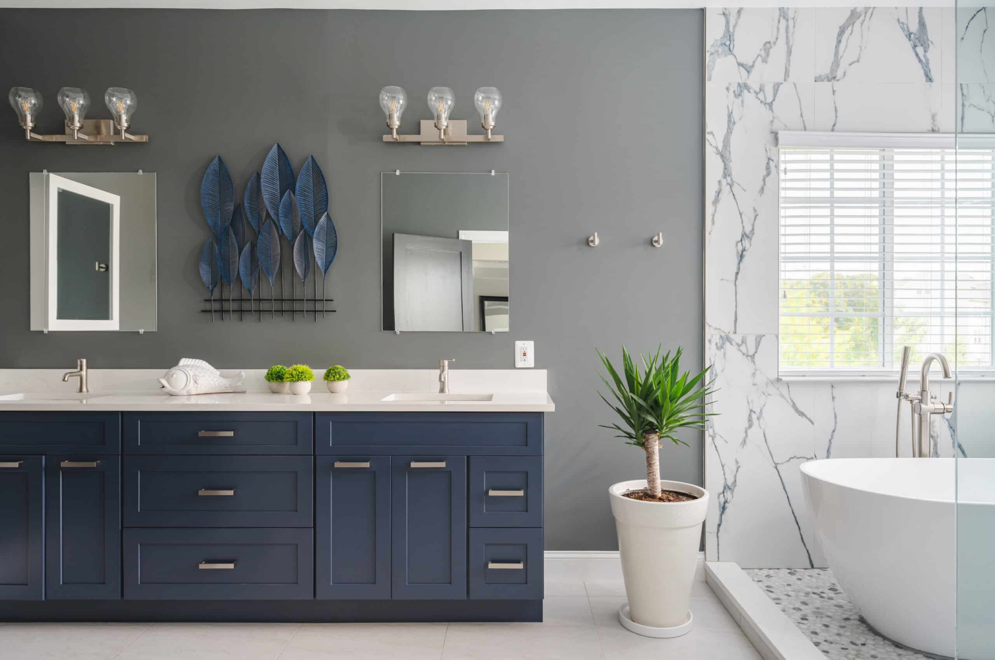 a bathroom with a blue vanity and a white tub